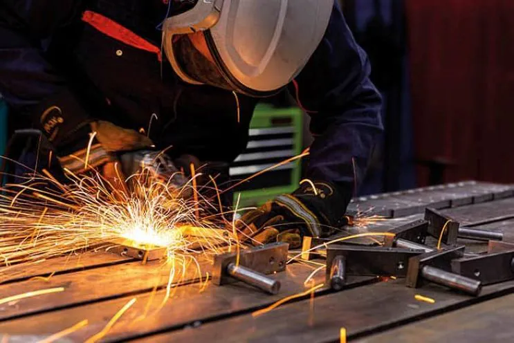 A welder working on a custom industrial oven at Spooner Industries, showcasing their expertise in creating bespoke technologies for various industries like food, environment, and paper.