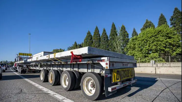 Carga de grandes dimensões no flatbed trailer, segura e devidamente sinalizada