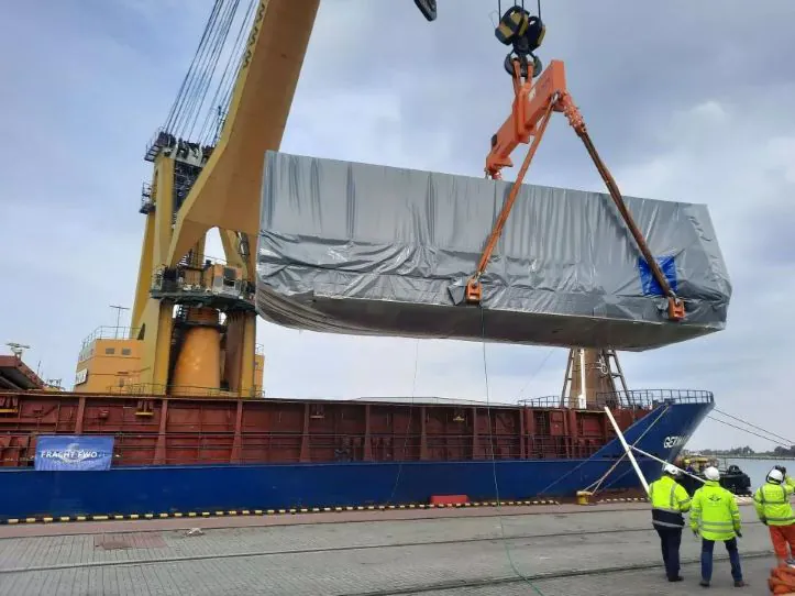 Ein Schiffskran lädt einen Schiffscontainer auf ein Frachtschiff und veranschaulicht die optimierte Frachtlogistik von Fracht FWO AG.