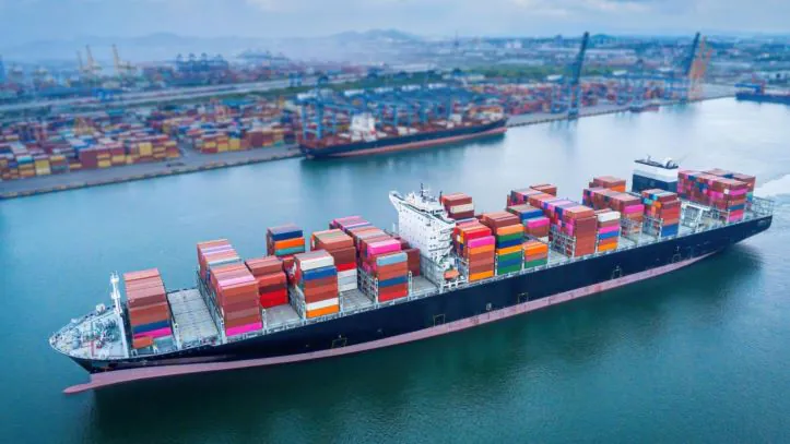 A container ship carrying cargo as it cruises into the port for unloading