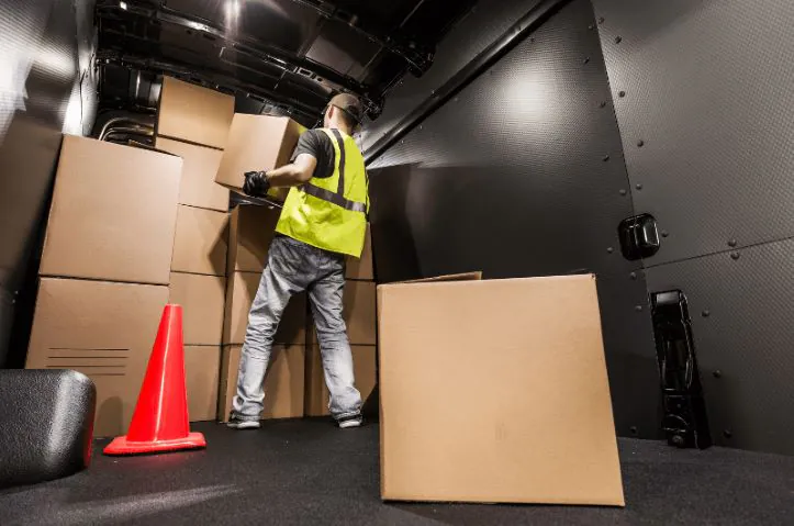 Warehouse worker organizing shipments inside the truck to optimize space and ensure secure loading