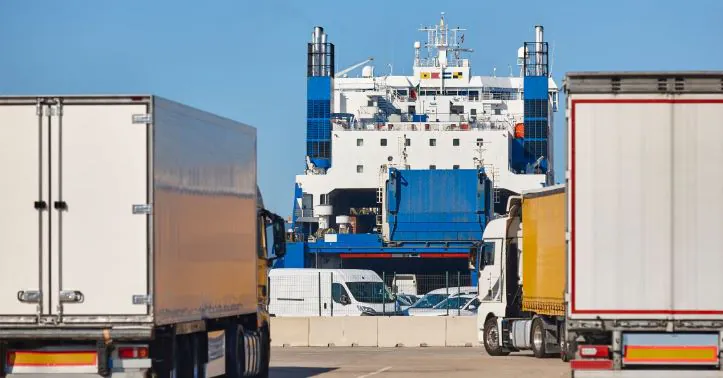Several trucks with trailers parked at a logistics port, ready for shipping