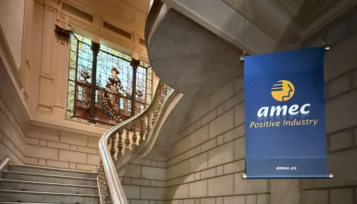 Entry into the AMEC office on Gran Via de les Corts Catalanes in Barcelona AMEC Positive Industry logo displayed in a historic hallway with a stained-glass window in the background