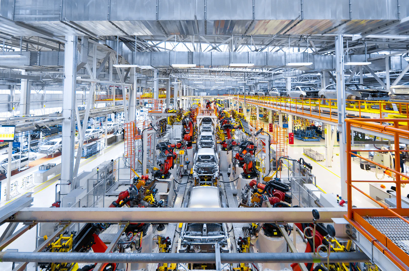 Automotive production line with vehicles in assembly, highlighting just-in-time logistics requirements
