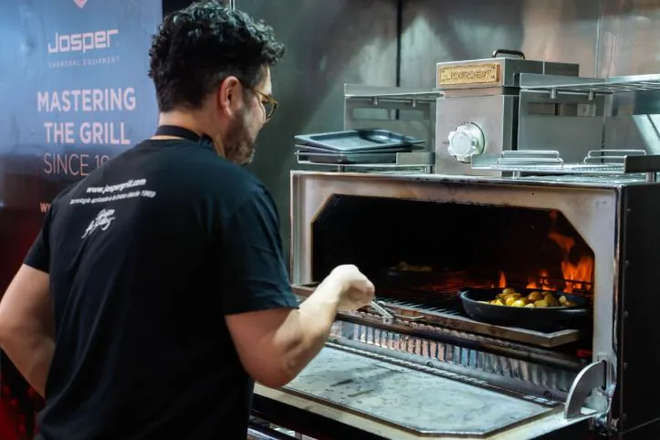 Horno brasa Josper Un hombre cocinando patatas en una parrilla Josper.